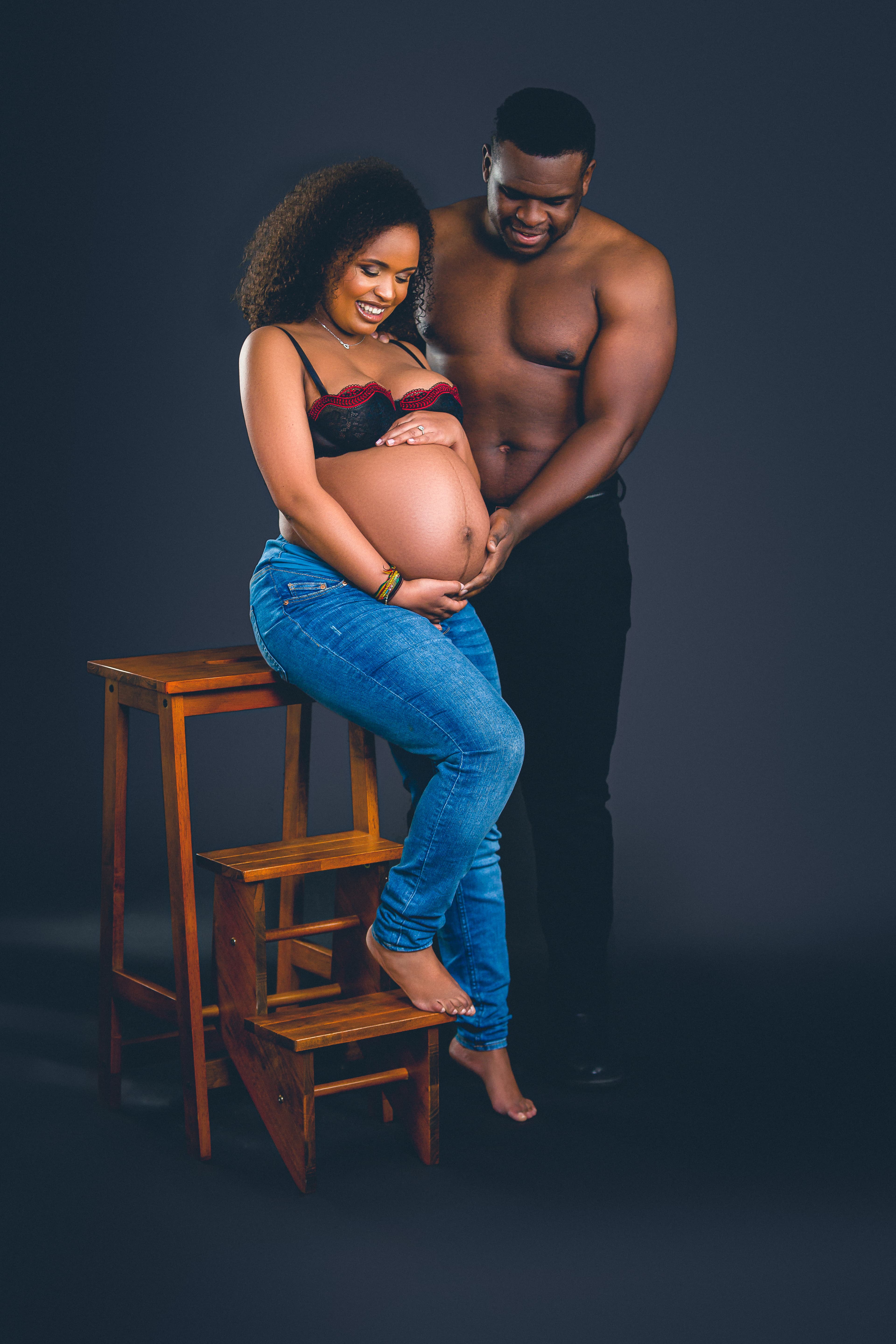 Couple maternity portrait — partner embracing bump in Edinburgh studio