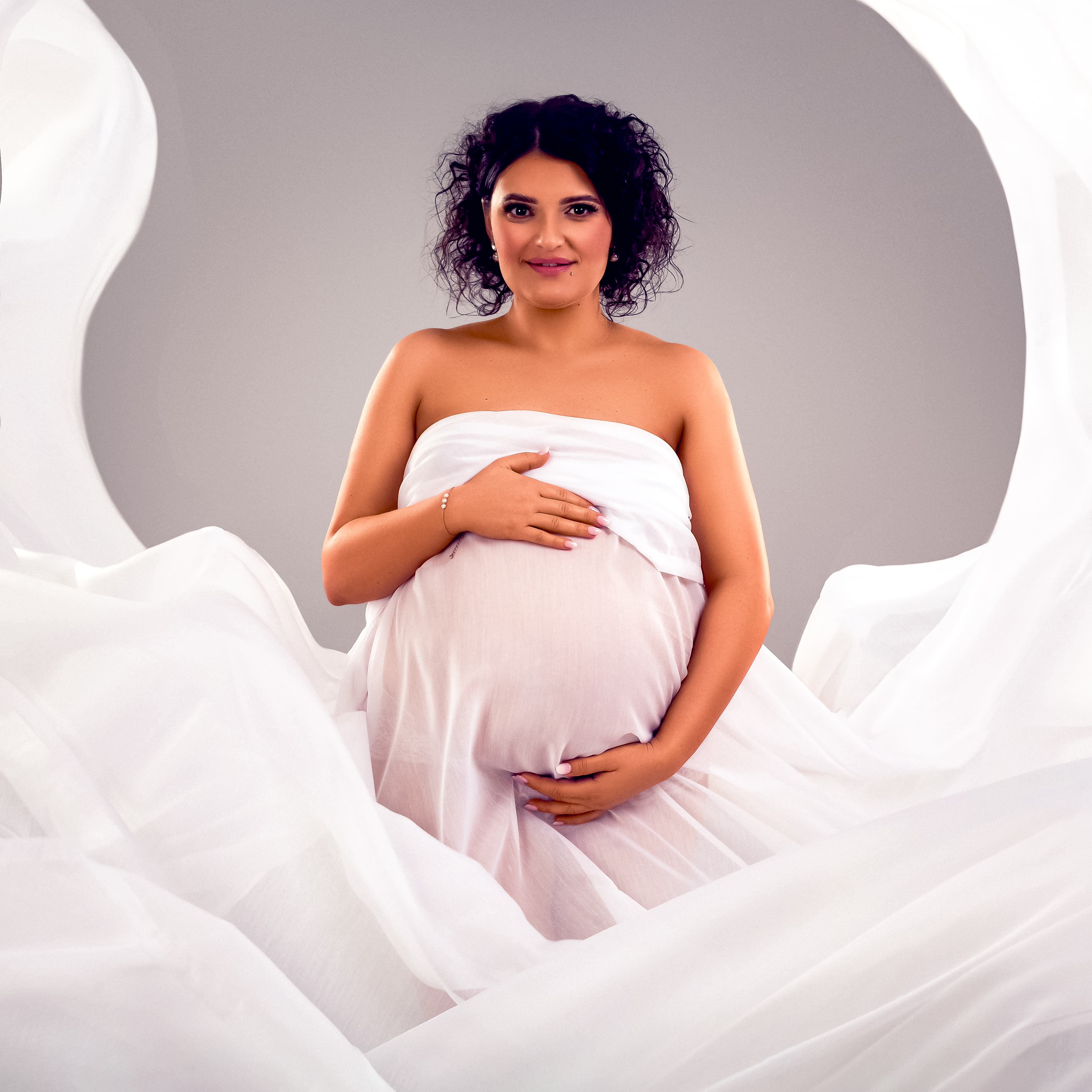 Elegant maternity portrait Edinburgh studio — flowing white fabric